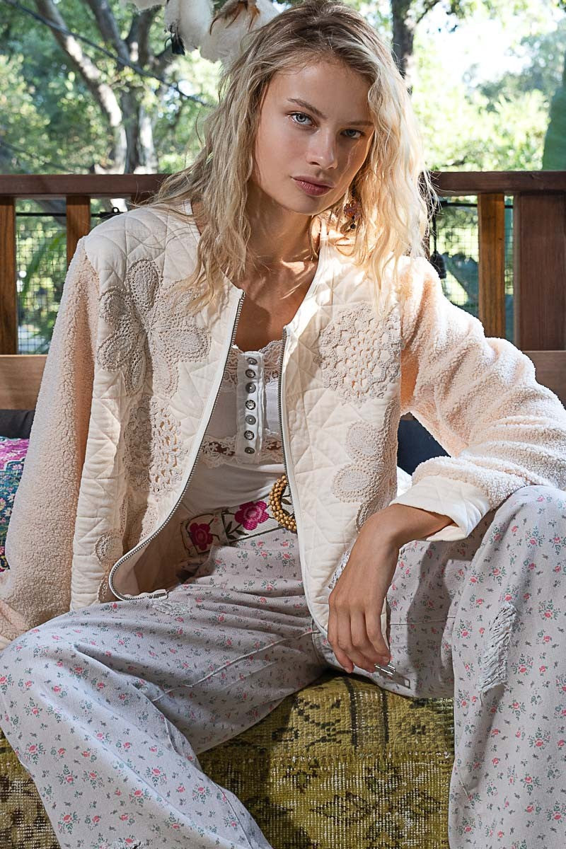 Imagine slipping into a quilted top with crochet appliques and furry sleeves – it’s like wrapping yourself in a cozy, stylish hug. The textured fabric feels warm and soft, perfect for those chill days when you just want to be comfortable but still look effortlessly chic. With the delicate crochet details, you can feel like a work of art, while the furry sleeves add that playful, free-spirited touch – it’s like you’re wearing a piece of whimsy.