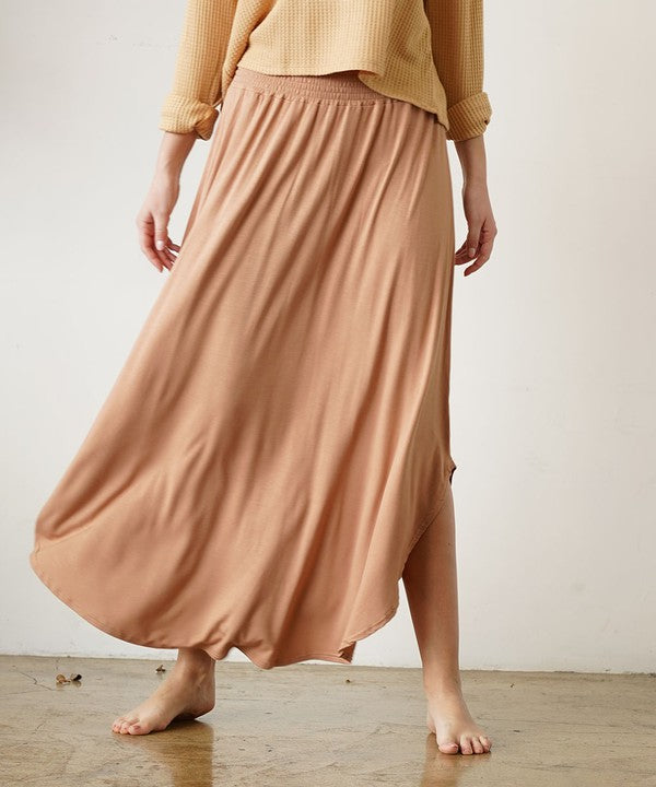 Experience ultimate comfort and effortless style with our luxurious Organic Bamboo Maxi Skirt. Crafted from a dreamy blend of organic bamboo and soft, stretchy spandex, this skirt offers an incredible drape and moves with you, offering a flattering fit that feels as good as it looks. The smocked elastic waist hugs gently, giving you all-day ease, while the flowing silhouette adds a graceful, boho touch to any outfit. This is a savvy choice for those who are eco-friendly or have skin conditions.
