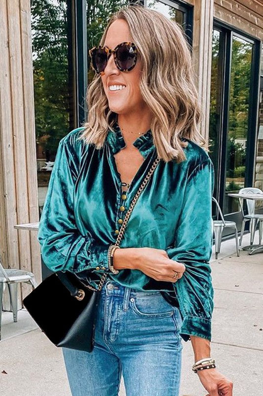 This luxurious velvet blouse is soft, skin-friendly, and lightweight, offering both comfort and elegance. Featuring a classic V-neck, button design, and feminine frilled neckline, it adds a timeless touch to your wardrobe. Perfectly paired with jeans, leggings, skirts, or boots, this versatile top is ideal for any occasion—whether casual, office, or a night out.. Several stunning colors available. All you need to do is pick!