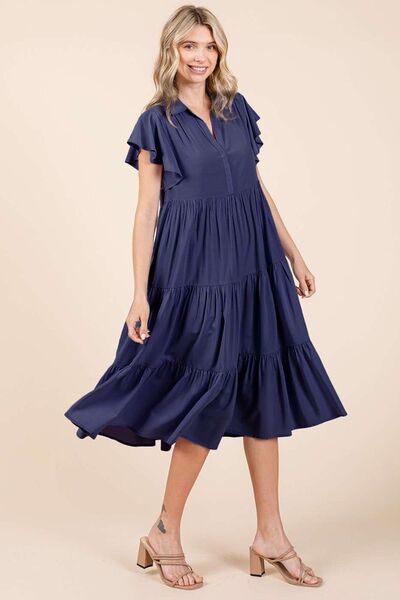 A ruffle sleeve, collared V-neck, tiered midi dress provides a simple feminine style. The tiered design creates a layered and textured look, adding dimension and flow. The midi length falls below the knee, making it versatile for both casual and more dressed-up occasions. Whether you're enjoying a sunny day in the park or headed to a rooftop dinner, this dress pairs effortlessly with sandals, boots, or layered jewelry for a carefree yet stylish vibe. Its timeless simplicity makes it a piece you