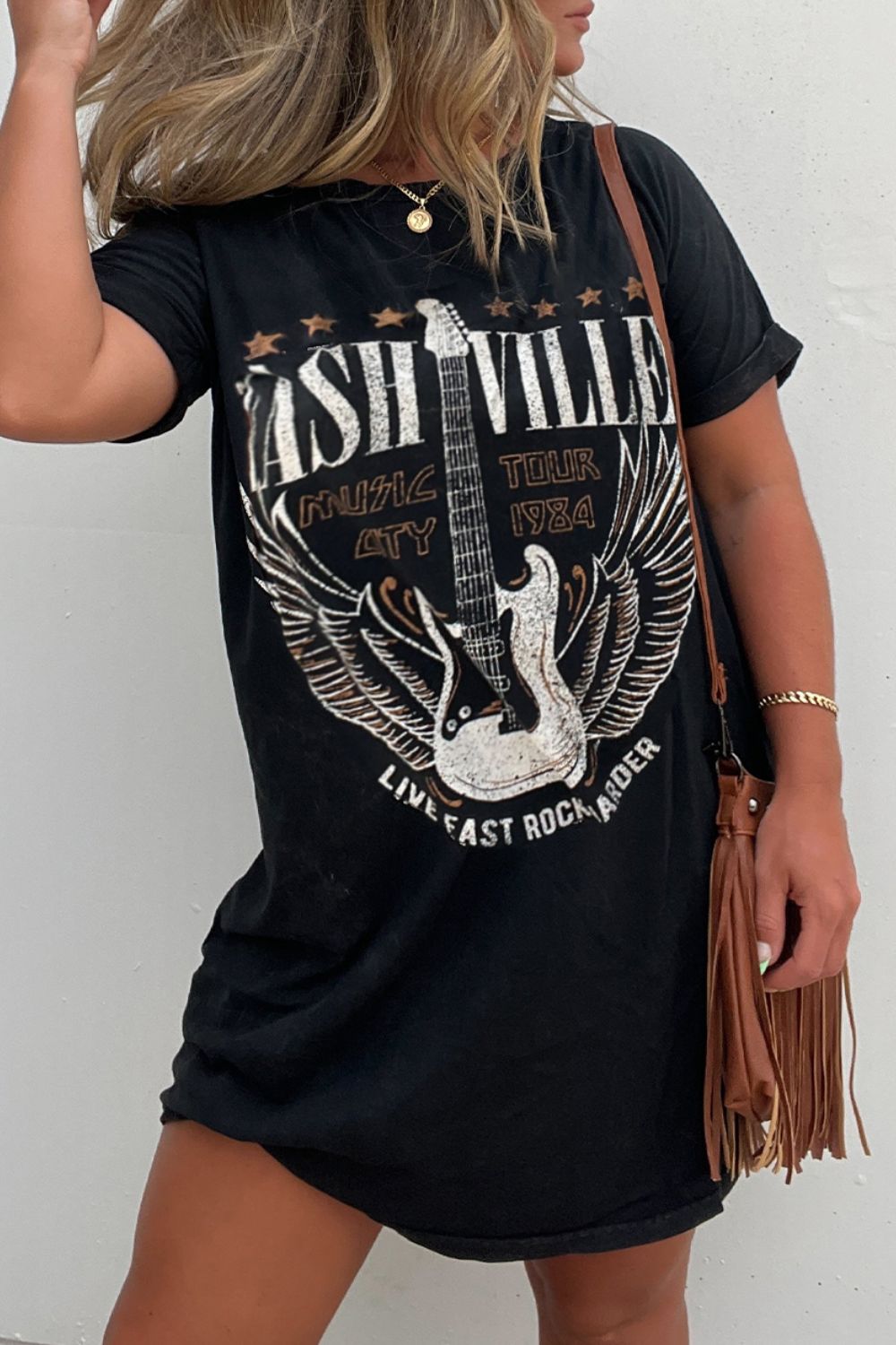 As the weather warms up this western music graphic t-shirt dress is going to be a fun and effortless pullover to pair with your favorite boots and accessories to get out the door! This short sleeve, black t-shirt dress can be worn out during the day running errands, meeting with friends, and then going to a festival or concert with a layer at night. Need a fringe handbag or a layer to complete the style? Just check out our handbag section and the layer/ outdoor section to complete the outfit.