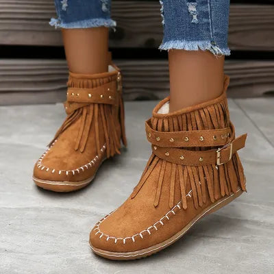 Step into the spirit of adventure with these Fringe Studded Suede Flat Boots. Designed for the free-spirited woman who craves comfort and style, these boots blend western ruggedness and bohemian flair. With soft, rich suede, fringed accents flowing with every step, bold rivets adorning the straps, these cowboy booties have a rebellious sparkle that are available in several earthy tones. Just right for a woman not afraid to make a statement.