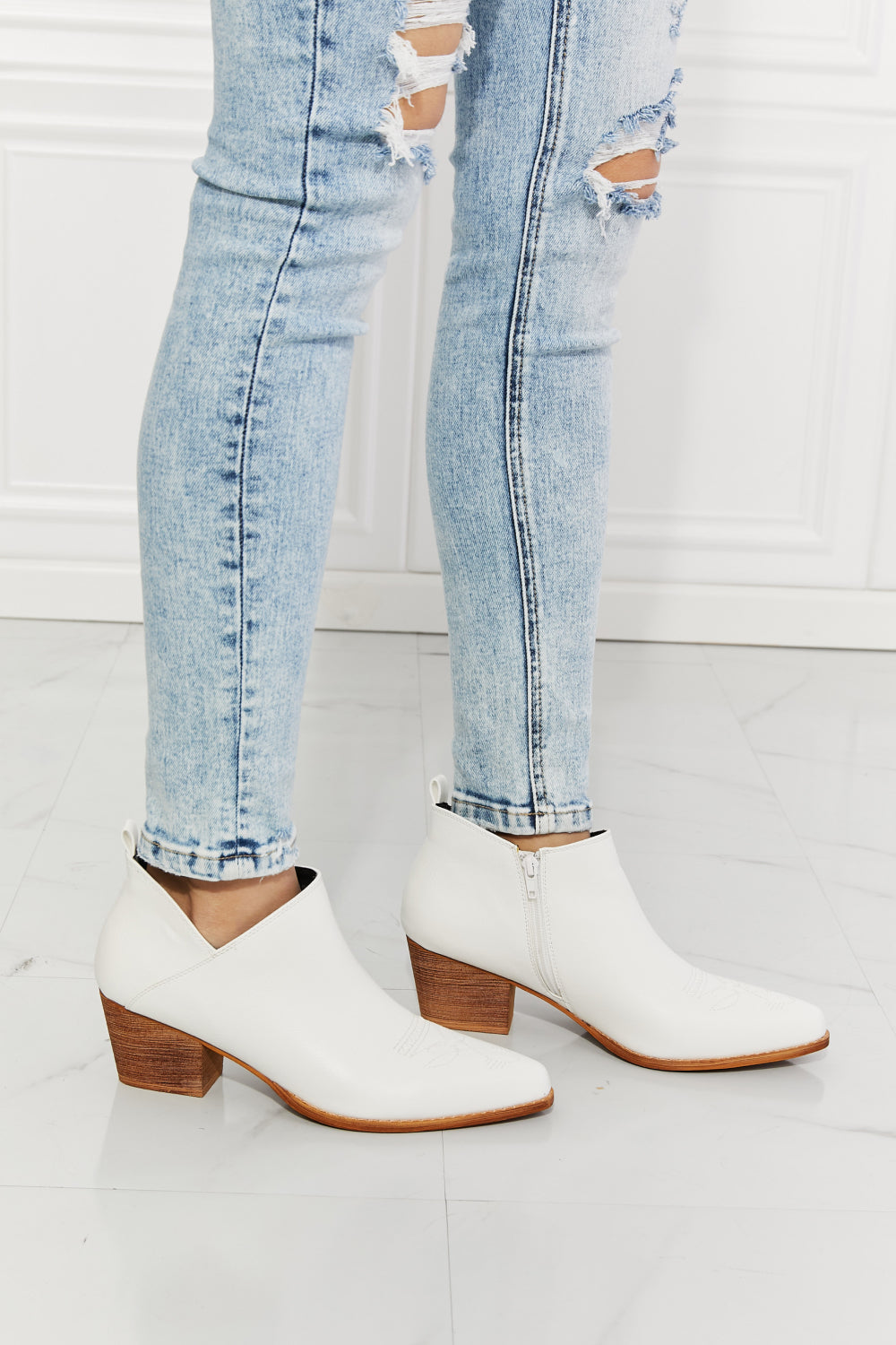 We've fallen in love with these crossover cowboy booties, with 2.5-inch stacked heel in white. These stunning crossover cowboy booties are designed to deliver both style and comfort. They feature a pointed toe, bold stitching, and a block heel for effortless all-day wear. They transition well from season to season. The embroidered design provides a classic touch and these cowboy booties pair well with distressed jeans or your favorite dresses.