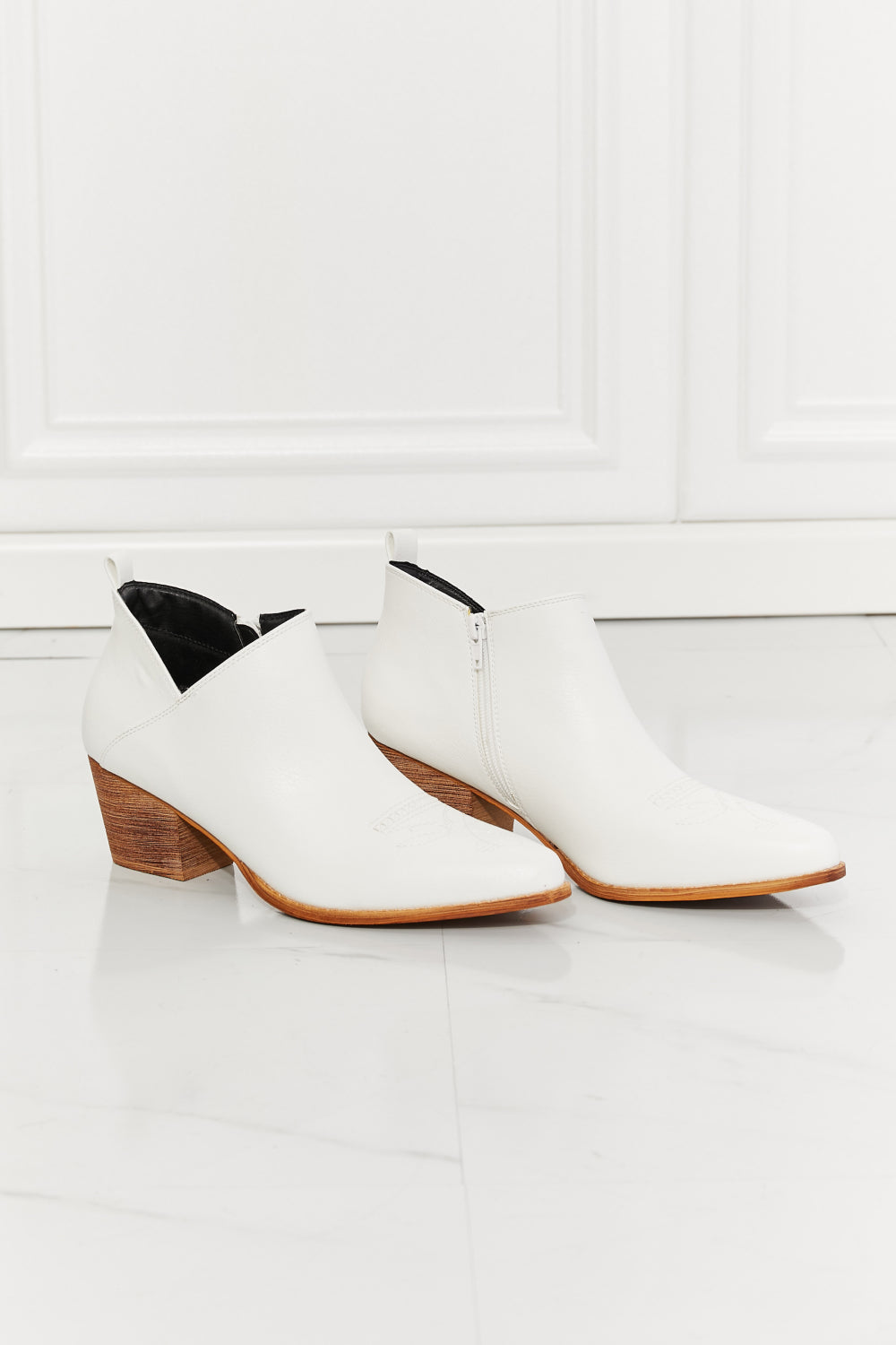 We've fallen in love with these crossover cowboy booties, with 2.5-inch stacked heel in white. These stunning crossover cowboy booties are designed to deliver both style and comfort. They feature a pointed toe, bold stitching, and a block heel for effortless all-day wear. They transition well from season to season. The embroidered design provides a classic touch and these cowboy booties pair well with distressed jeans or your favorite dresses.