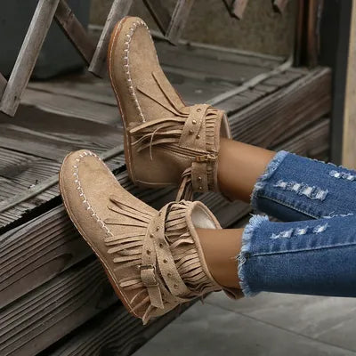 Step into the spirit of adventure with these Fringe Studded Suede Flat Boots. Designed for the free-spirited woman who craves comfort and style, these boots blend western ruggedness and bohemian flair. With soft, rich suede, fringed accents flowing with every step, bold rivets adorning the straps, these cowboy booties have a rebellious sparkle that are available in several earthy tones. Just right for a woman not afraid to make a statement.
