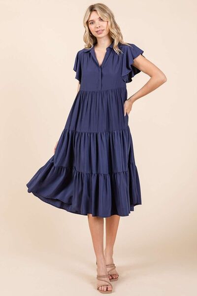 A ruffle sleeve, collared V-neck, tiered midi dress provides a simple feminine style. The tiered design creates a layered and textured look, adding dimension and flow. The midi length falls below the knee, making it versatile for both casual and more dressed-up occasions. Whether you're enjoying a sunny day in the park or headed to a rooftop dinner, this dress pairs effortlessly with sandals, boots, or layered jewelry for a carefree yet stylish vibe. 