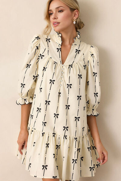 This half sleeve mini dress with flirty ruffles at your neck and cuffs is feminine, flowy, and romantic. The bow print adds another distinct charm to this tiered mini dress.