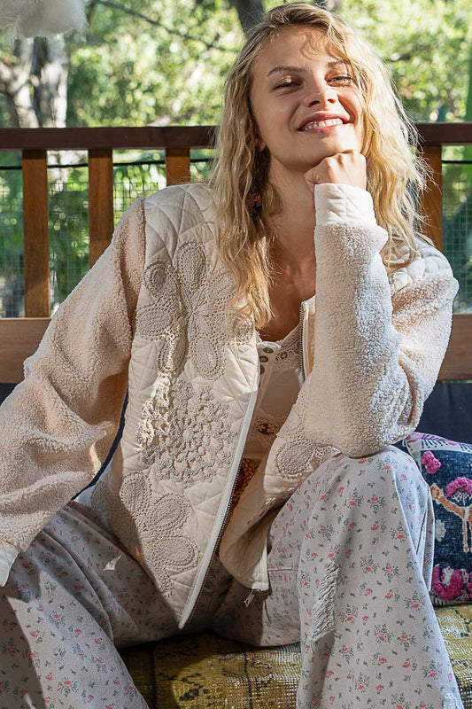 Imagine slipping into a quilted top with crochet appliques and furry sleeves – it’s like wrapping yourself in a cozy, stylish hug. The textured fabric feels warm and soft, perfect for those chill days when you just want to be comfortable but still look effortlessly chic. With the delicate crochet details, you can feel like a work of art, while the furry sleeves add that playful, free-spirited touch – it’s like you’re wearing a piece of whimsy.